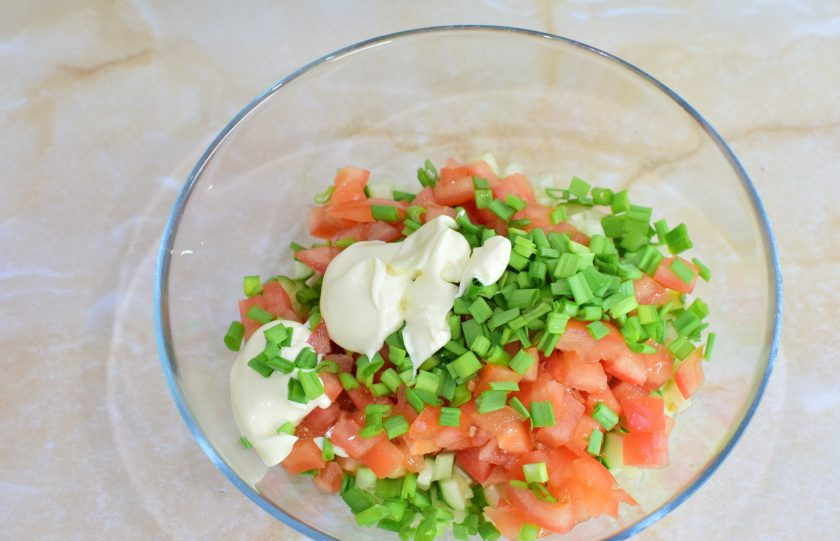 1. Этап. Крабовый салат с помидорами и огурцами: Добавьте нарезанный зеленый лук и майонез. Все ингредиенты перемешайте между собой. При необходимости можно добавить соль и специи. Для аромата можно воспользоваться измельченным чесноком.
