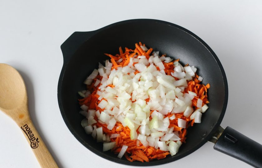 1. Этап. Курица на рисовой подушке: Разогрейте сковороду с маслом. Выложите тертую морковь и нарезанный кубиками лук.