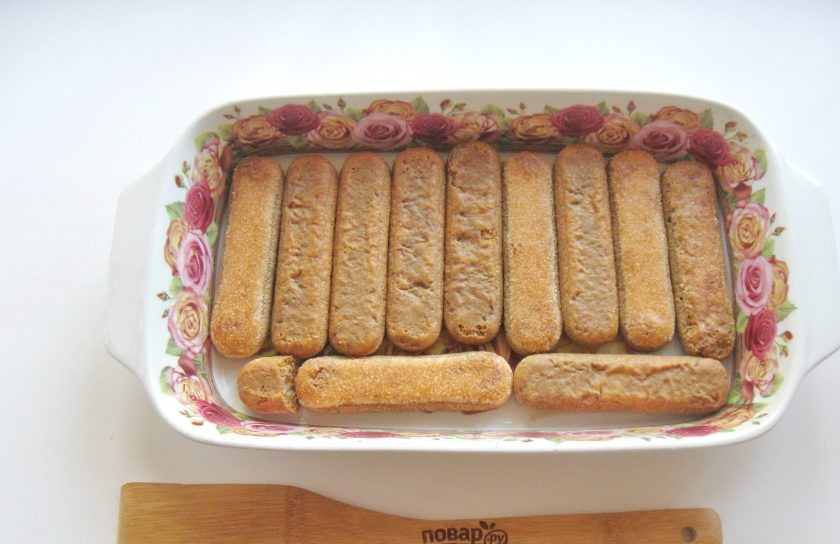 1. Этап. Торт Тирамису: Быстро макайте печенье в кофе с коньяком и выкладывайте в форму. Выложите таким образом 12 штук печенья.