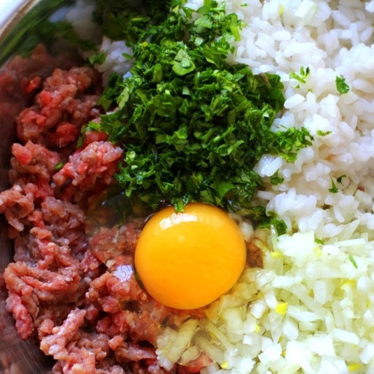 1. Этап. Голубцы с мясом: В большой миске смешиваем фарш, яйца, отваренный до полуготовности рис, мелко нарезанный репчатый лук и зелень. Солим, перчим и хорошо перемешиваем.