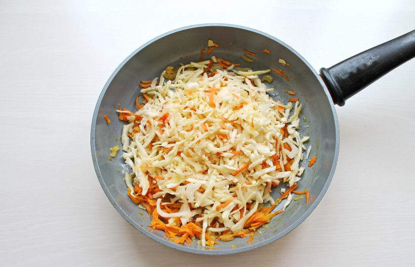 1. Этап. Украинский борщ с квашеной капустой: Квашеную капусту промойте и отожмите. Порежьте если нужно и добавьте в сковороду с обжаренными овощами. Обжаривайте все еще 5 минут, перемешивая.