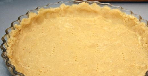 1. Этап. Миндальный пирог: 3. Возьмите низкую форму. Смажьте ее дно и боковины маслом. Выложите в нее тесто. Аккуратно разровняйте пальцами так, чтобы толщина коржа была не более 1 см. Вилкой сделайте проколы по всему пласту.