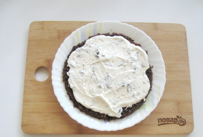 1. Этап. Шоколадный торт с черносливом и орехами: Испеченный корж охладите и разрежьте вдоль на три части. Смажьте два коржа кремом.