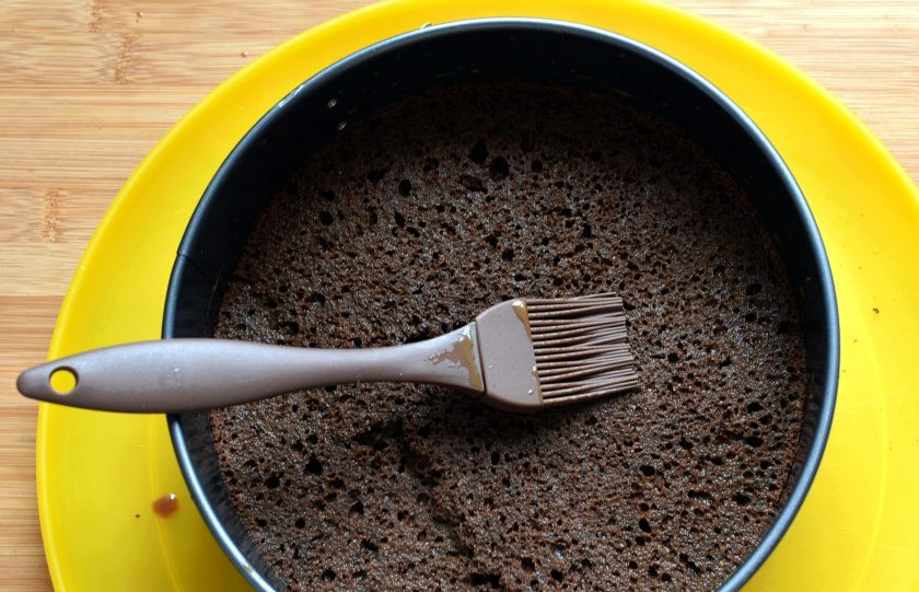 1. Этап. Маковый торт с йогуртовым муссом и белым шоколадом: Разрежьте бисквит на два коржа, уложите один в разъемную форму и пропитайте оба коржа сладким крепким кофе с молоком, ароматизировав его миндальным экстрактом. Кофе должен быть охлажденным.