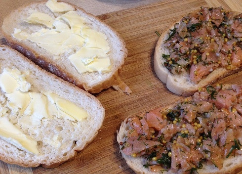 1. Этап. Горячий сэндвич с лососем: Два ломтика батона смазываем сливочным масло. А на оставшиеся ломтики выкладываем рыбную начинку.