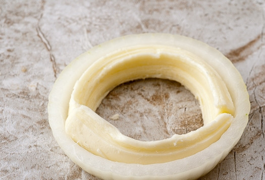 1. Этап. Оригинальные пончики с беконом: 2. Очистите и нарежьте средними кольцами лук. Разделите на тонкие колечки. Аккуратно разделите пополам сыр и поместите в колечко лука вот таким образом.