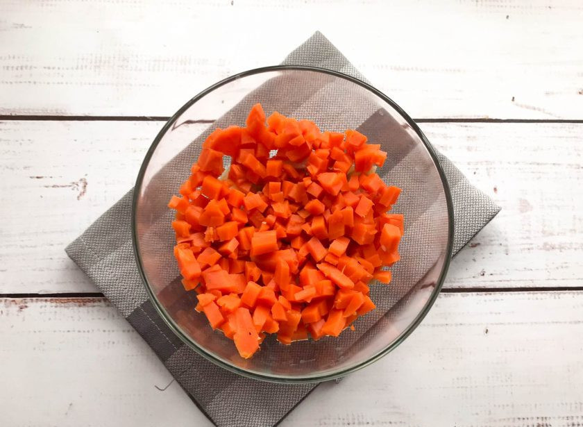 1. Этап. Оливье с печенью: Вареную морковь почистите, нарежьте кубиками и добавьте к картофелю.