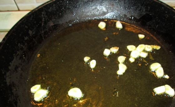 1. Этап. Гарнир из замороженного шпината: Чеснок очистите и крупно нарубите. В сковороде разогрейте оливковое масло. Если его нет, используйте обычное подсолнечное, но обязательно без запаха. Обжаривайте чеснок в масле несколько минут.