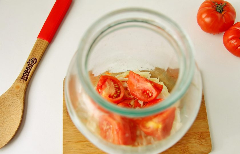 1. Этап. Квашеная капуста с помидорами: В банку слоями выложите капусту, чередуя ее с нарезанными помидорами.