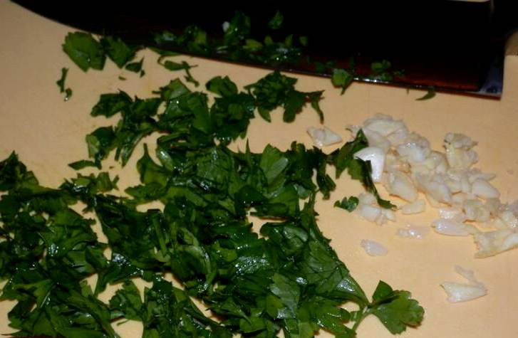 1. Этап. Салат с лисичками и зеленью: Чеснок нарезаем на пластинки и перетираем его с солью, петрушку промываем и измельчаем.