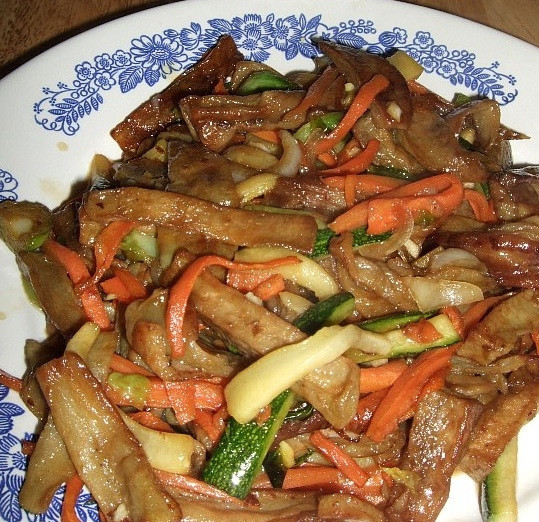 1. Этап. Баклажаны по-китайски в кляре: 6. Уменьшить огонь до среднего, в сковороду добавить ложку сахара, уксус, соевый соус, все пожареные овощи и лук. Жарить интенсивно помешивая в течение 20 секунд. Выключить плиту. Выдавливаем несколько долек чеснока. Блюдо готово, можно подавать к столу! Очень важно не передержать баклажаны в соусе, иначе они будут не такими хрустящими как хотелось бы.