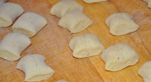 1. Этап. Ньёки: Разделите тесто на кусочки, скатайте каждый из них в жгут. Затем нарежьте их на кубики, размером около полутора сантиметров. Отваривайте ньеки в подсоленной воде до готовности и подавайте, сдобрив маслом или полив соусом.