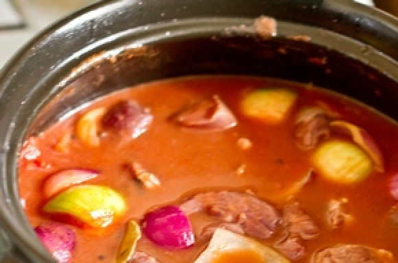 1. Этап. Стифадо из говядины: В кастрюле с толстым дном разогрейте 1 ст.л. растительного масла. Обжариваем лук 5 минут, добавляем томатную пасту и готовим еще минуту. Кладем томаты (размятые) вместе с соком. Также добавляем мясо с маринадом и заливаем сверху горячей водой, чтоб покрыть содержимое кастрюли. Доводим до кипения, убавляем огонь до минимума и тушим 1 час или чуть больше, до мягкости мяса.