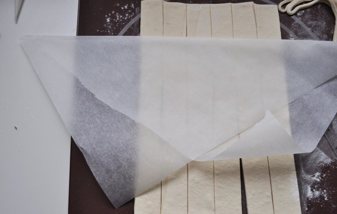 1. Этап. Слоеные трубочки: Берем бумагу для выпекания и нарезаем ее на треугольники, их должно быть столько же, сколько у вас получилось полосок из теста.