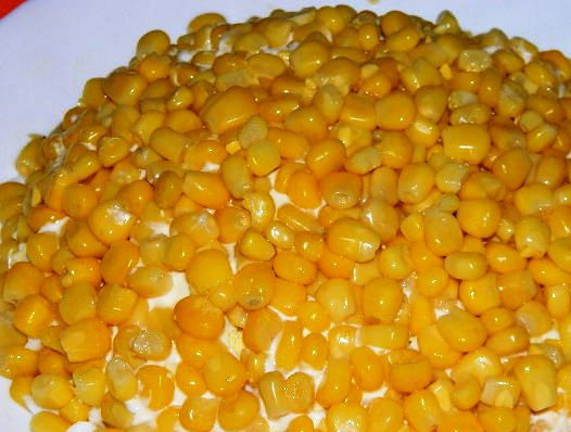 1. Этап. Салат Подсолнух с грибами: Аккуратно распределите по всей поверхности кукурузу.