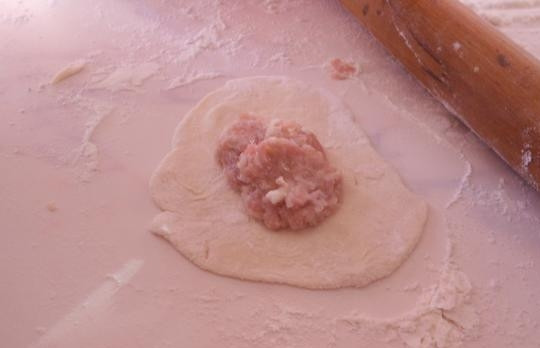 1. Этап. Пельмени во фритюре: Тесто раскатайте в жгут, нарежьте порциями, каждую из которых затем раскатайте в лепёшку. Посередине выложите ложку фарша.