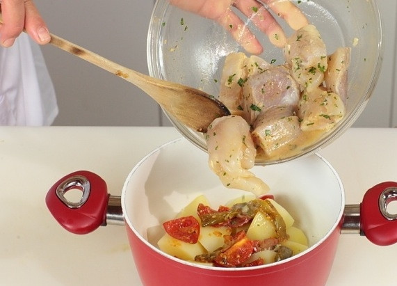 1. Этап. Тажин с рыбой: На дно тажина укладываем крупно нарезанный очищенный картофель, далее - нарезанные помидоры и перец. Сверху укладываем куски рыбы.