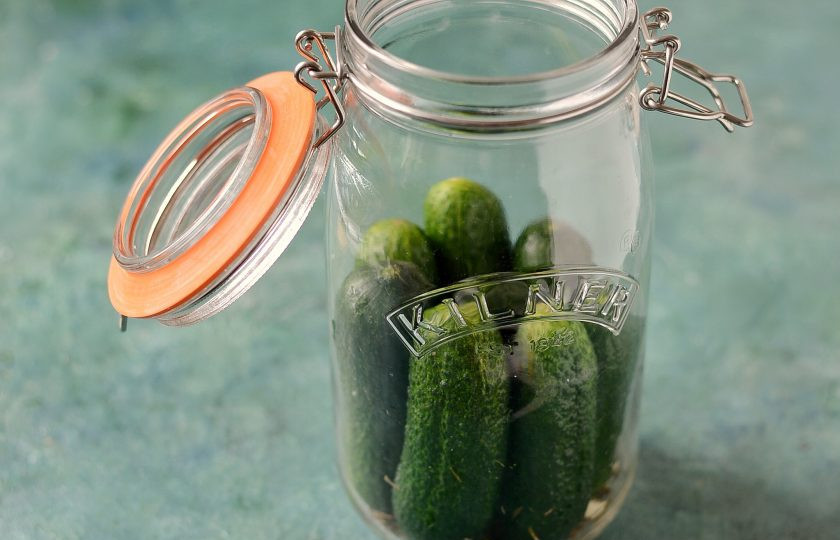 1. Этап. Маринованные огурцы на 1.5 литровую банку: Плотно уложите огурцы в банку наполовину. Затем добавьте вторую часть приправы и чеснока. Уложите оставшуюся часть огурцов.