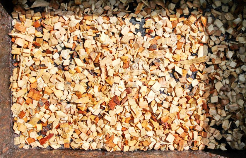 1. Этап. Минтай горячего копчения: Специальную щепу для копчения смочите немного водой и выложите ровным, не толстым слоем на дно коптильни.