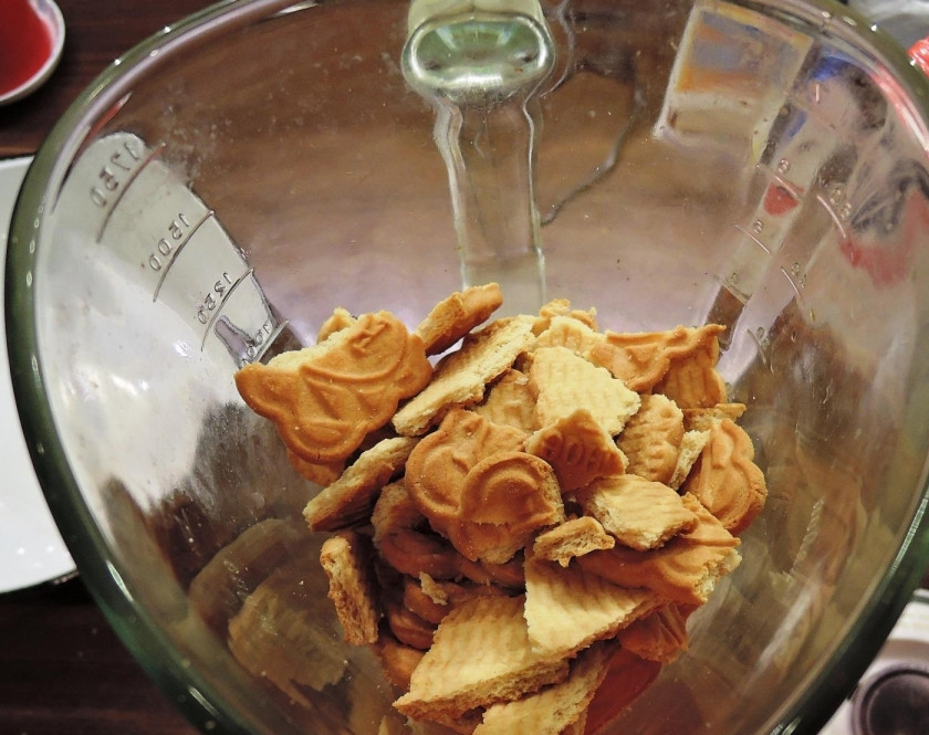 1. Этап. Чизкейк с персиками: 1. Печенье ломаю на кусочки и кладу в блендер, перемалываю до крошки, которую перекладываю в миску.