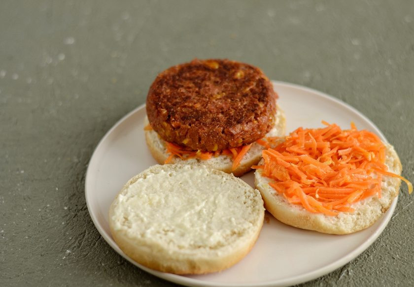 1. Этап. Бургер с ананасом: Теперь соберите бургер. Нижнюю часть булочки намажьте постным майонезом, сверху выложите морковь по-корейски и котлету.