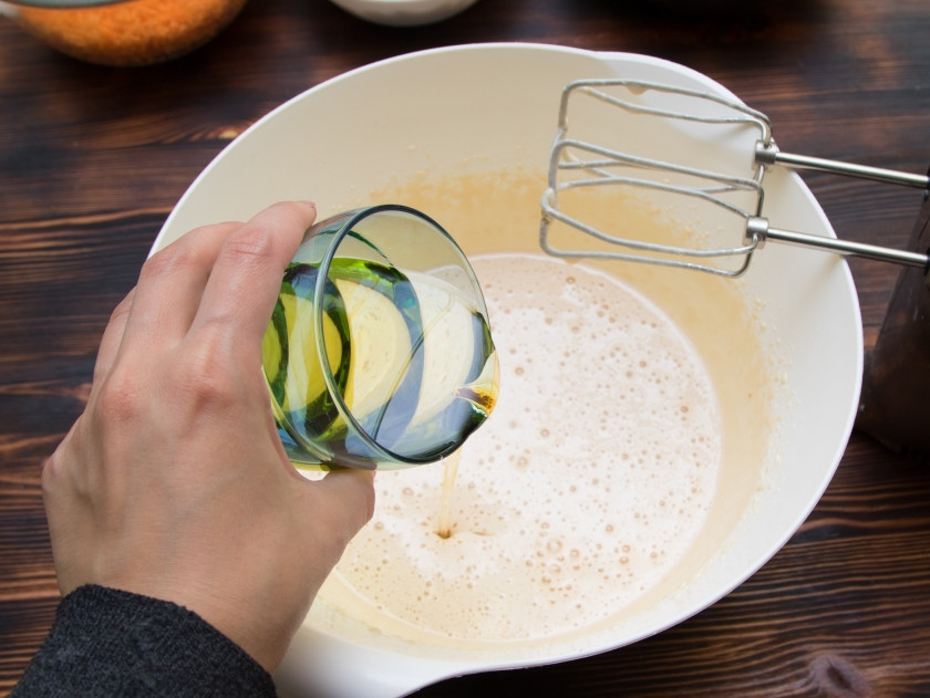 1. Этап. Морковный торт классический: Вольем в яично-сахарную массу масло и еще раз немного взобьем.