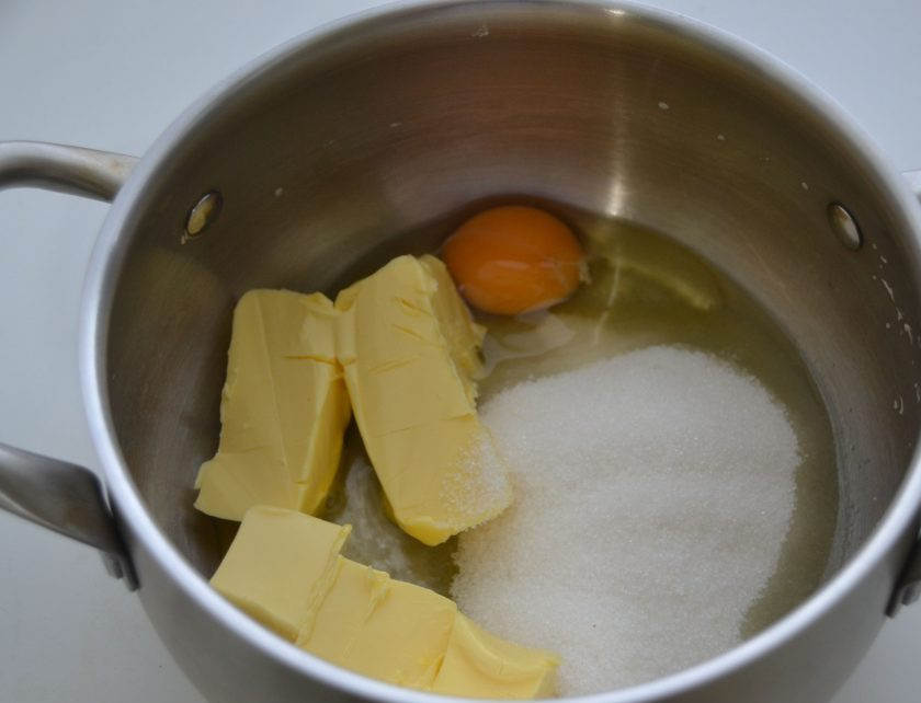 1. Этап. Пирог с грушами и сливами: В емкость для замешивания теста выложите размягченное сливочное масло, сахар, вбейте 1 яйцо.