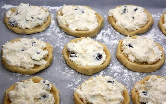 1. Этап. Ватрушки: 5. Теперь приготовим противень, застелем его пергаментом для выпечки и выложим на него тесто. Накладываем творожную начинку. Смазываем творожную поверхность яичной смесью.