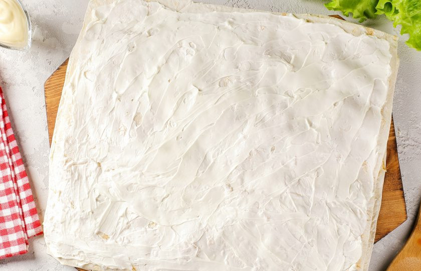 1. Этап. Лаваш с семгой: Накройте начинку вторым листом лаваша и смажьте его творожным сыром.