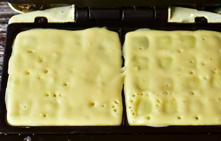 1. Этап. Норвежские вафли: Хорошо разогрейте электровафельницу. Налейте в нее тесто и немного его разровняйте ложкой. Закройте крышку вафельницы.