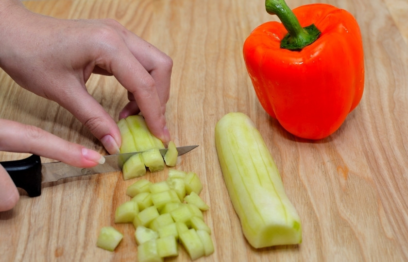 1. Этап. Салат из цветных макарон: Огурец очистите от шкурки, болгарский перец от семян. Нарежьте кубиками, равными по величине.