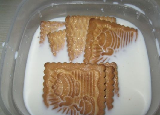 1. Этап. Торт с печеньем и творогом: 1. В емкость налейте 100 миллилитров молока, порционно выложите в молоко печенье и оставьте каждую партию на 40-60 секунд.