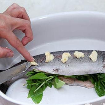 1. Этап. Форель, запеченная с базиликом: 4. На ту сторону форели, где делали надрезы, раскладываем кусочки сливочного масла. До температуры сто девяносто градусов разогреваем духовку и отправляем туда запекаться форель. Запекаем минут пятнадцать-двадцать.