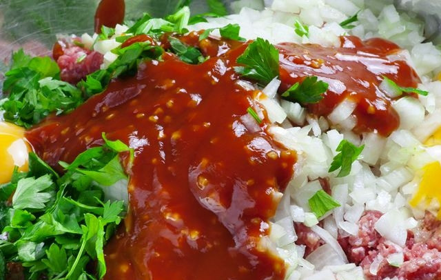 1. Этап. Веллингтон: Первым делом мясной фарш смешиваем с тремя яйцами, кетчупом, а также мелко нарезанными луком, чесноком и зеленью. Солим, перчим, хорошенько перемешиваем.