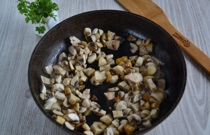 1. Этап. Салат с курицей и шампиньонами: Шампиньоны очистите и нарежьте мелким кубиком. Обжарьте грибы на сковороде с растительным маслом.