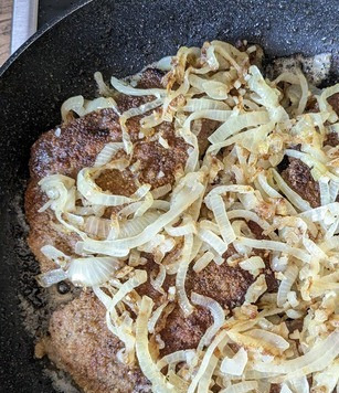 1. Этап. Шницель из говяжьей печени: После переворачивания сразу добавить лук в сковороду, чтобы немного подогреть его.