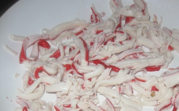 1. Этап. Салат с жареными крабовыми палочками и грибами: Крабовые палочки нарежьте соломкой. Обжарьте их до румяного цвета в масле (пару минут).