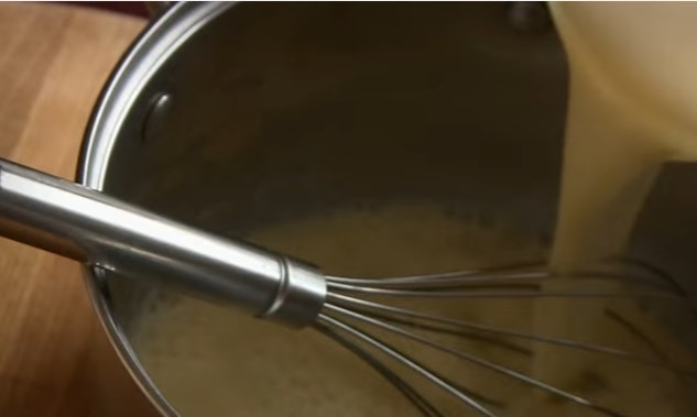 1. Этап. Слойки из слоеного теста с кремом Патисьер: 3. В кастрюлю отправьте остаток молока и 50 г сахара. На медленном огне доведите до кипения. Тонкой струйкой влейте горячее молоко в крем, постоянно его помешивайте.