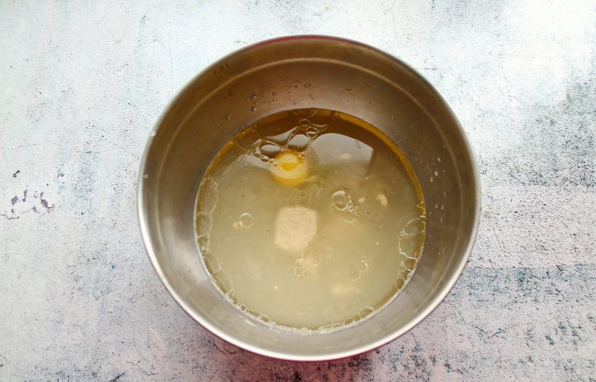 1. Этап. Пирожки с солеными груздями и рисом: Теплую воду налейте в миску, выложите прессованные дрожжи, соль, сахар и разбейте яйцо. Все хорошо перемешайте до однородности.