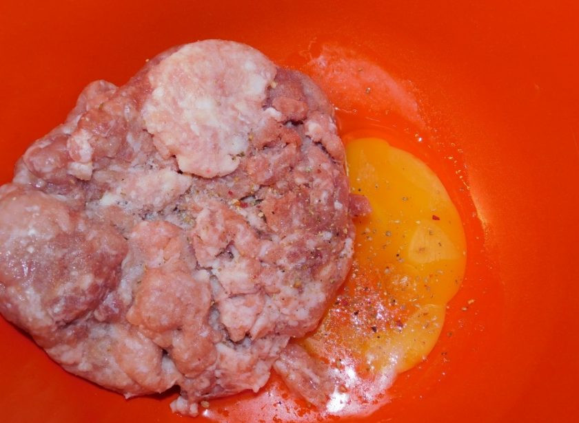 1. Этап. Тефтели в белом соусе с чесноком и базиликом: Добавьте в фарш яйцо, соль и специи. Перемешайте.