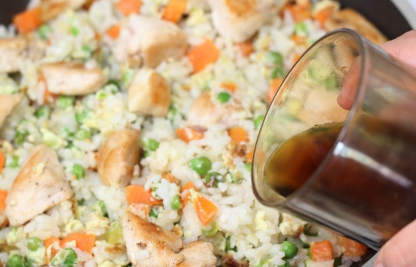 1. Этап. Жареный рис с курицей: Добавьте обжаренную курочку, затем соевого соуса и перемешайте.