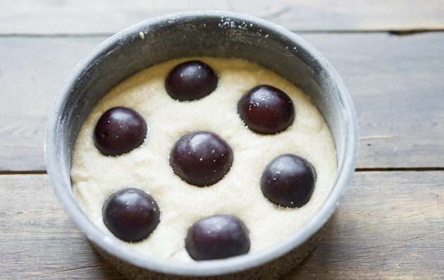 1. Этап. Пирог со сливами на скорую руку: 3. Форма для выпечки у меня диаметром 16 см. Смазываем её сливочным маслом и присыпаем мукой. Затем выкладываем в форму тесто, украшаем его сливами, разрезанными пополам, и отправляем запекаться пирог на 35 минут при 180 градусах.