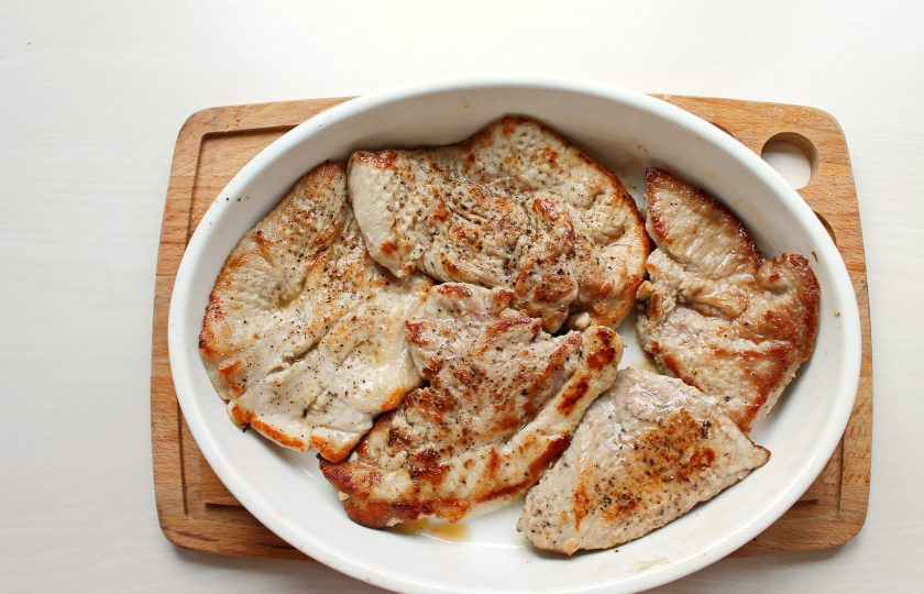 1. Этап. Свинина с маринованными помидорами: В сковороду налейте растительное масло и разогрейте на сильном огне. Обжарьте стейки с двух сторон до золотистой корочки, примерно по 5-6 минут. Выложите мясо в смазанную растительным маслом форму для запекания.