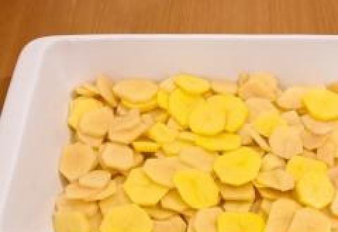 1. Этап. Картофель, запеченный с сыром: Картофель чистим, нарезаем на тонкие круглые ломтики (как на фото) и выкладываем в форму для запекания, предварительно смазанную маслом.