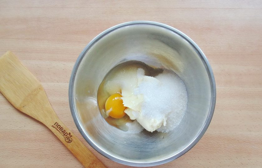 1. Этап. Песочный пирог с малиновым вареньем: Разбейте яйцо в миску с маслом и сахаром.