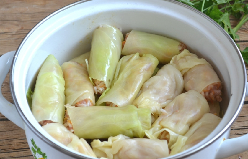 1. Этап. Голубцы, фаршированные мясом и рисом: Сложите голубцы в небольшую кастрюлю в два слоя, предварительно застелив дно кастрюли несколькими листьями капусты. Залейте водой, чтобы покрыла голубцы, и варите на медленном огне 20 минут.