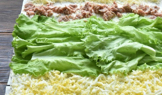 1. Этап. Тунец в лаваше: Следующие ряды из салатных листьев, измельченного тунца и натертого сыра.