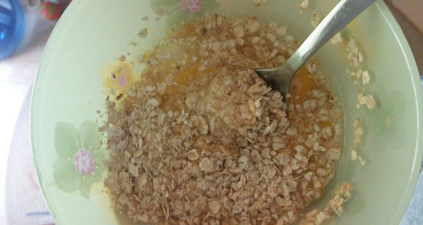 1. Этап. Омлет с овсяной кашей: В миску вбейте сырые куриные яйца, добавьте несколько ложек овсяных хлопьев и все тщательно перемешайте.