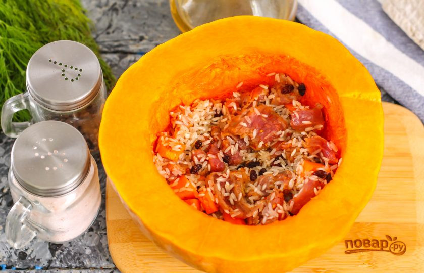 1. Этап. Плов в тыкве в духовке: Тыкву очистите от семян, стараясь не повредить или не пробить дно, промойте. Выложите внутрь овоща приготовленную начинку. Очистите репчатый лук от кожуры и нарежьте.