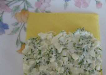 1. Этап. Сырные трубочки с острой начинкой: 2. Пластинку плавленого сыра разворачиваю на столе, выкладываю начинку на половину поверхности.